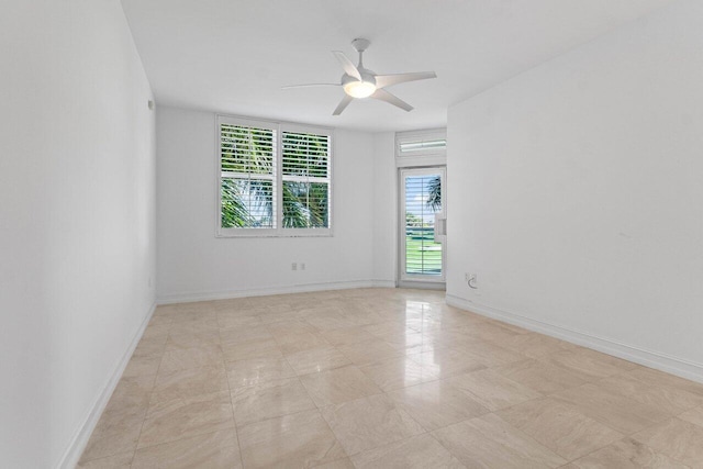 empty room featuring ceiling fan and baseboards