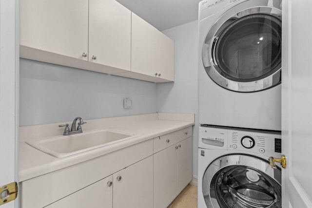 laundry area featuring a sink, cabinet space, and stacked washer / dryer