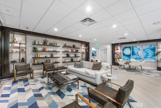 living room featuring visible vents, a drop ceiling, and recessed lighting