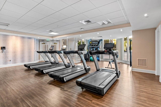 workout area featuring wood finished floors, visible vents, and baseboards