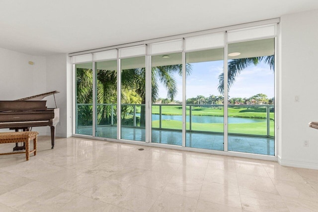 interior space with a water view, baseboards, and a wall of windows