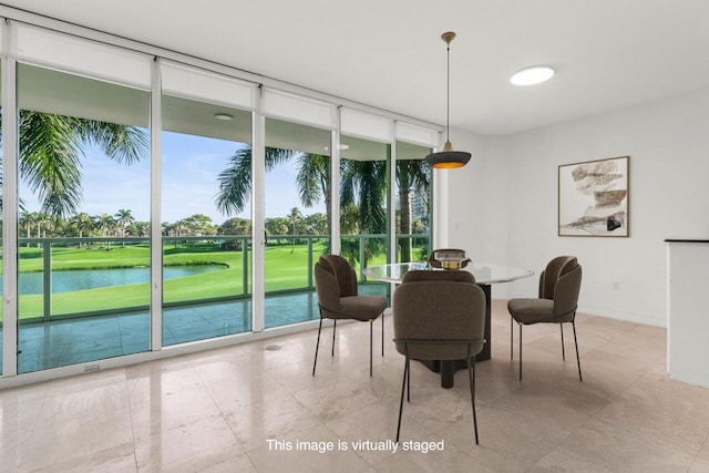 dining room with floor to ceiling windows, a water view, and baseboards