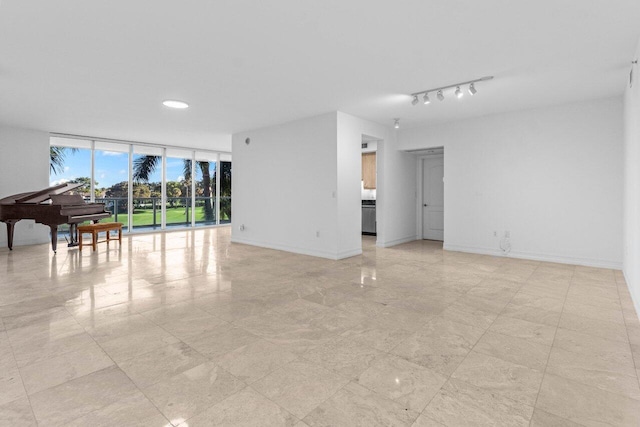 living area with expansive windows, baseboards, and track lighting