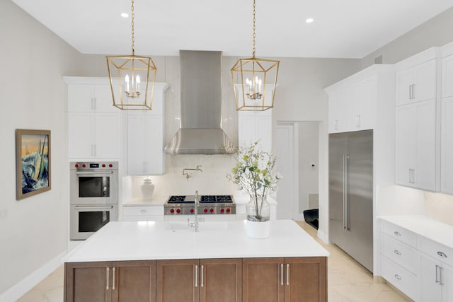 kitchen with wall chimney exhaust hood, white cabinetry, stainless steel appliances, and a kitchen island with sink