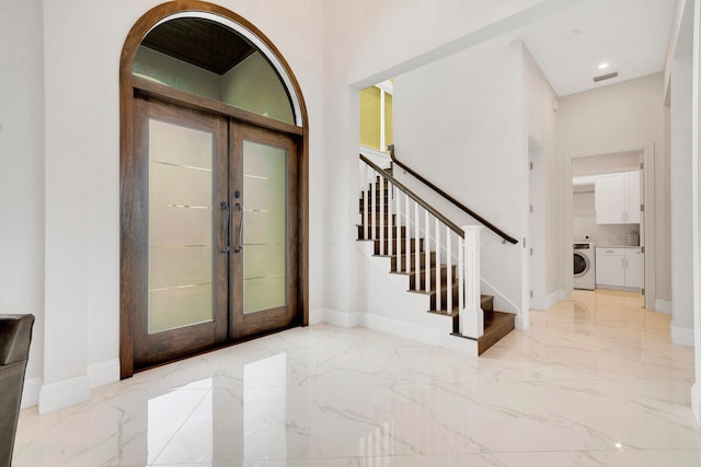 foyer entrance featuring washer / clothes dryer and french doors