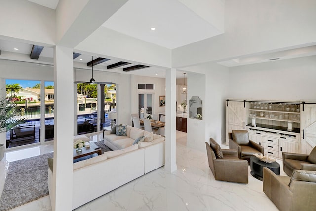 living room with beamed ceiling and a barn door