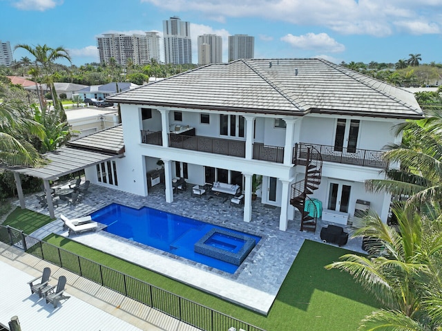 back of house with a pool with hot tub, a patio area, and french doors