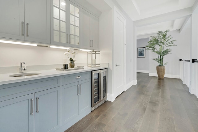 kitchen with dark wood-type flooring, beverage cooler, and sink