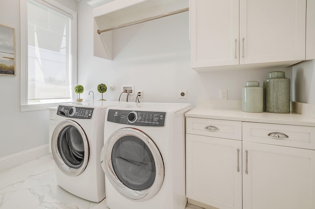 laundry room with washer and dryer and cabinets