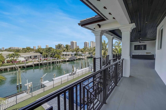 balcony with ceiling fan and a water view