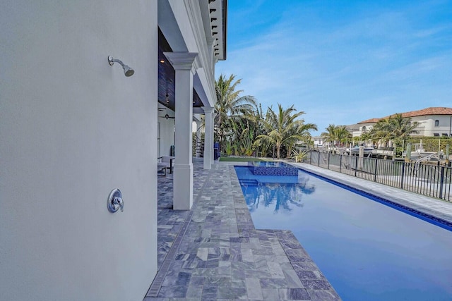 view of swimming pool featuring a patio area, an in ground hot tub, and a water view