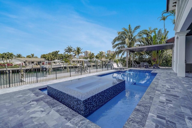 view of pool with a patio area, a water view, and an in ground hot tub