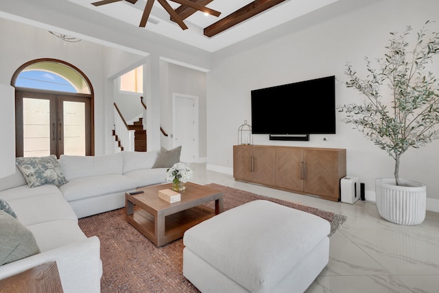 living room featuring ceiling fan, french doors, beamed ceiling, and a high ceiling