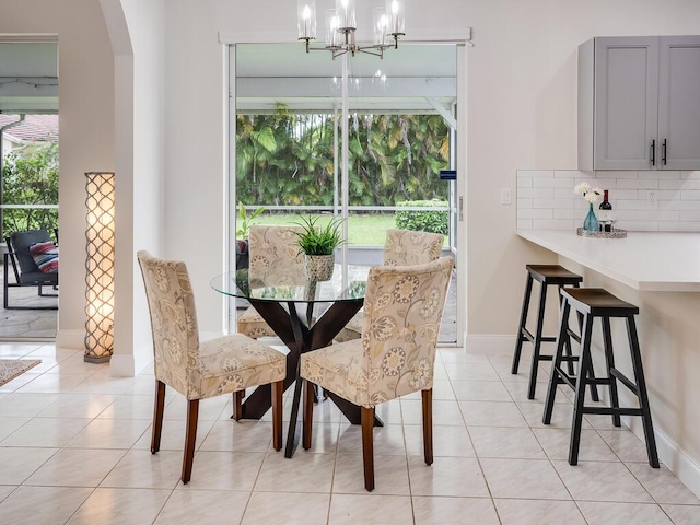 tiled dining room featuring an inviting chandelier