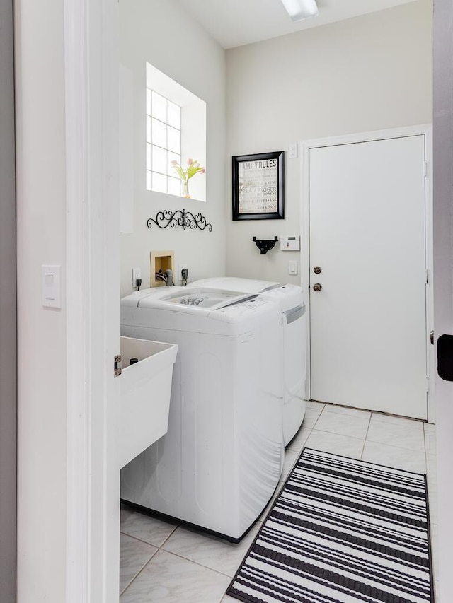 laundry area with washing machine and dryer and light tile patterned floors