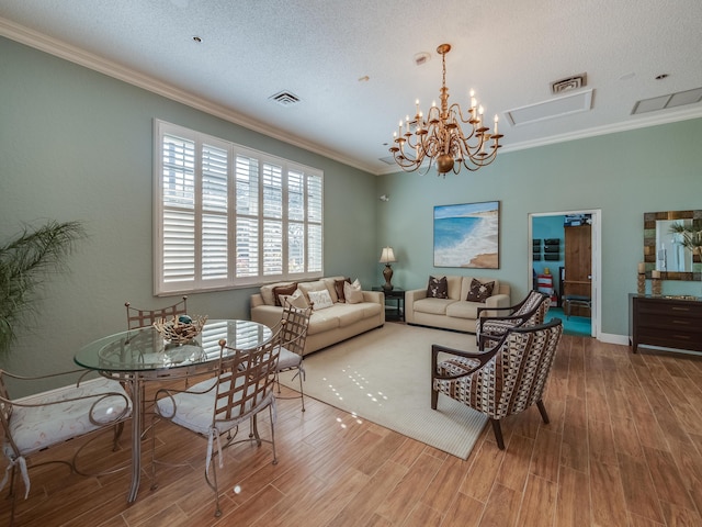 living room featuring wood-type flooring, a textured ceiling, and ornamental molding