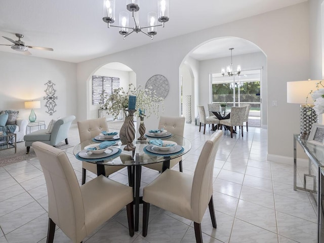 dining area with light tile patterned floors and ceiling fan with notable chandelier