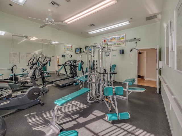 gym featuring ceiling fan and a textured ceiling