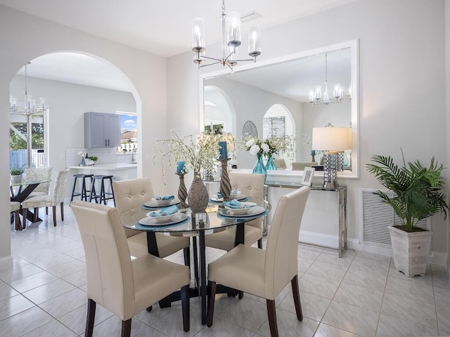 dining area with light tile patterned floors and a chandelier