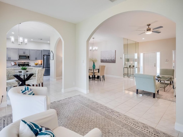 living room with light tile patterned floors and ceiling fan with notable chandelier