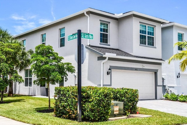 view of front of property featuring a garage and a front lawn