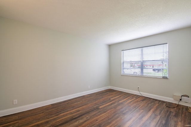 empty room with dark hardwood / wood-style flooring