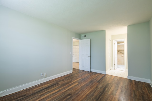 unfurnished bedroom with dark hardwood / wood-style flooring