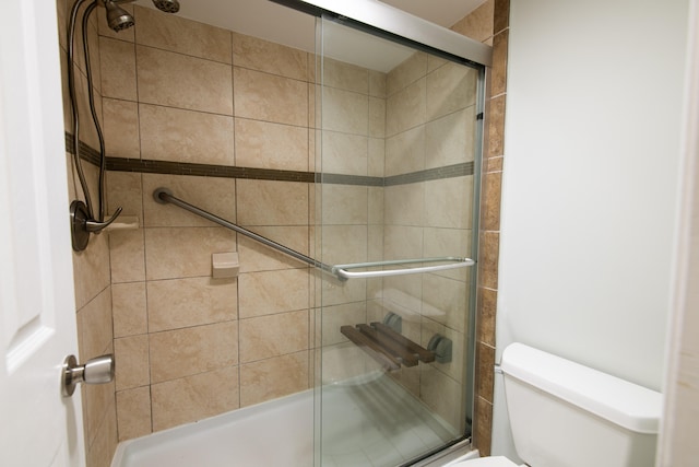 bathroom featuring an enclosed shower and toilet