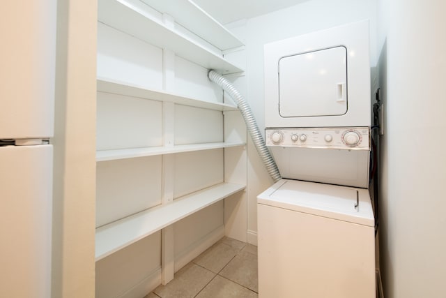 laundry area featuring stacked washer / dryer and light tile patterned floors