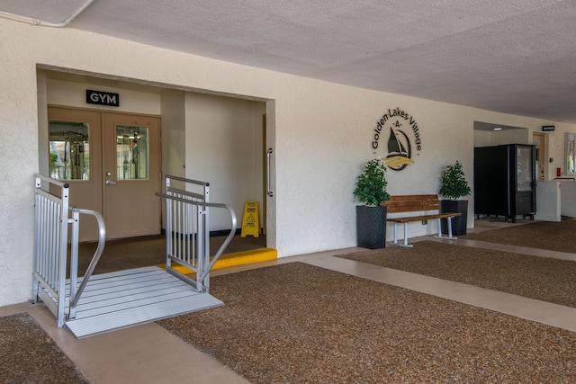 view of exterior entry featuring stucco siding and french doors