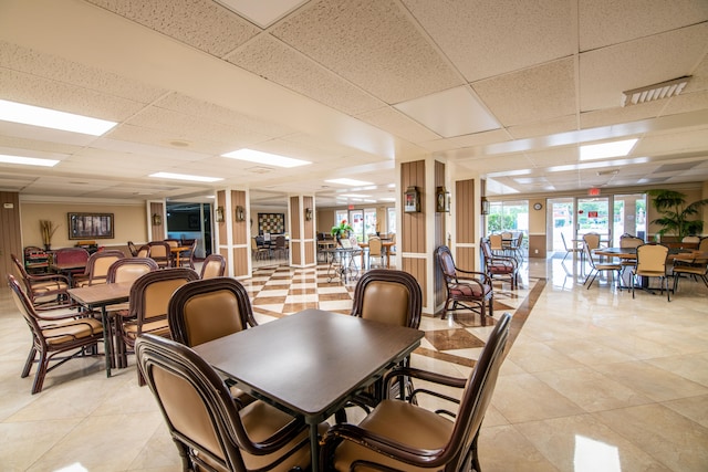 tiled dining room with a paneled ceiling