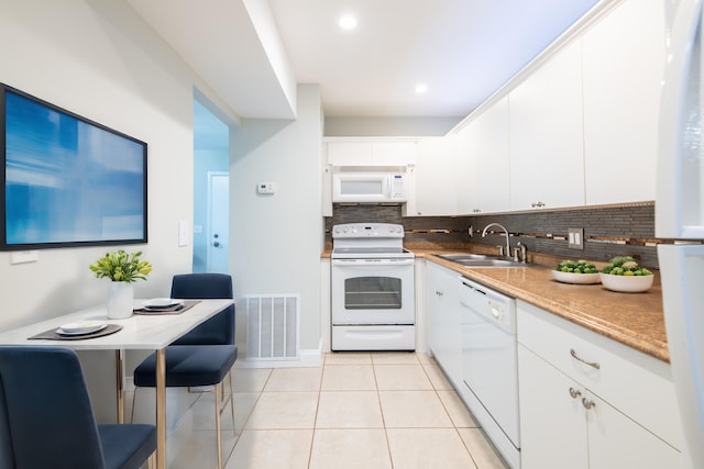 kitchen with light tile patterned flooring, a sink, white appliances, visible vents, and decorative backsplash