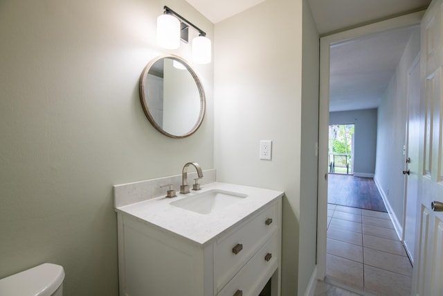 bathroom with toilet, vanity, and tile patterned floors