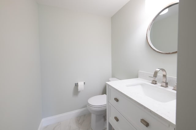 half bath with marble finish floor, vanity, toilet, and baseboards