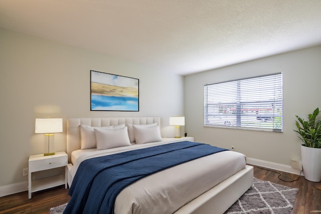 bedroom featuring baseboards and dark wood-type flooring