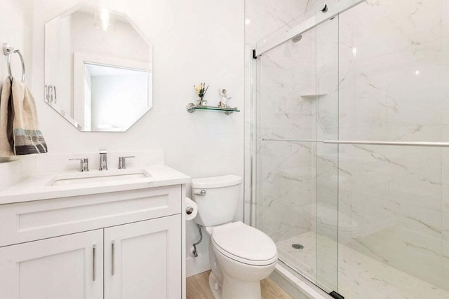 bathroom featuring vanity, toilet, hardwood / wood-style floors, and a shower with shower door