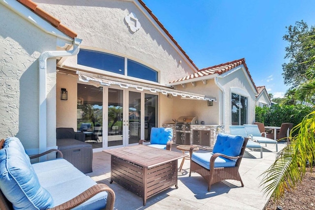 exterior space featuring an outdoor kitchen, a patio, an outdoor living space, and french doors