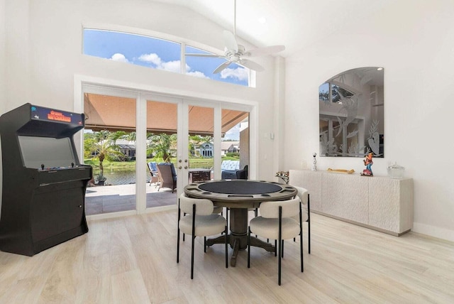 dining space featuring high vaulted ceiling, ceiling fan, light wood-type flooring, and french doors