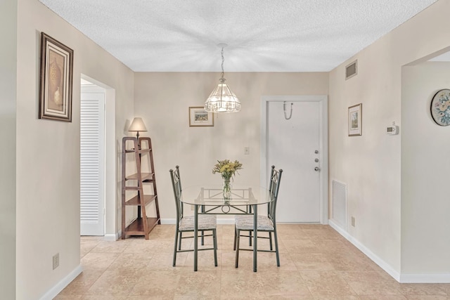 dining room featuring a textured ceiling and a notable chandelier