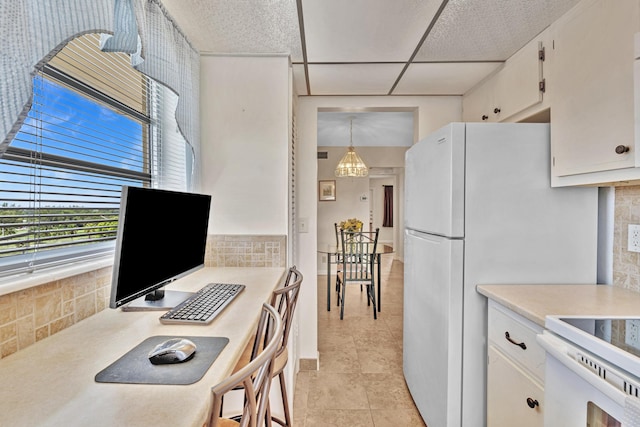 kitchen featuring white cabinetry, a chandelier, backsplash, light tile patterned floors, and hanging light fixtures