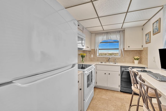 kitchen with white appliances, light tile patterned floors, sink, decorative backsplash, and white cabinets