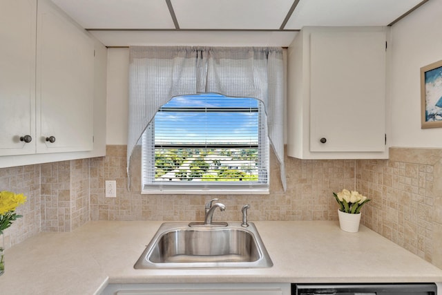 kitchen with dishwasher, sink, backsplash, and white cabinetry