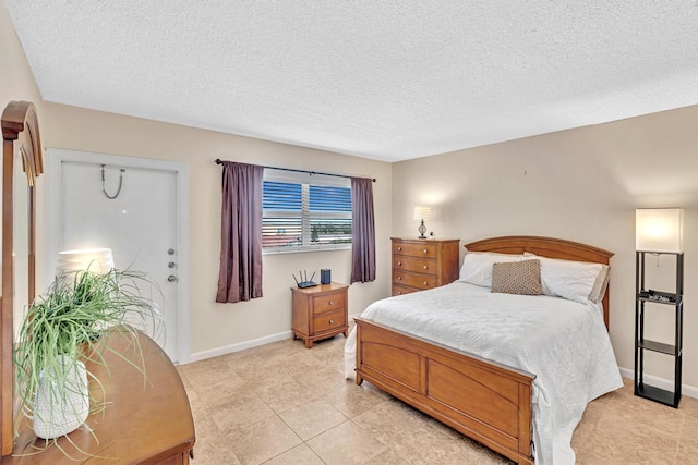 bedroom featuring a textured ceiling and light tile patterned floors