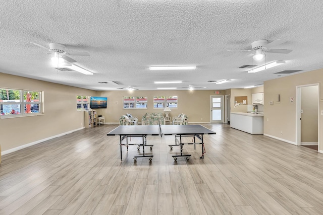 dining space with a textured ceiling, ceiling fan, and light hardwood / wood-style floors