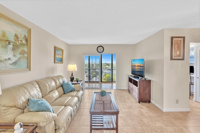 living room with a textured ceiling and light tile patterned floors