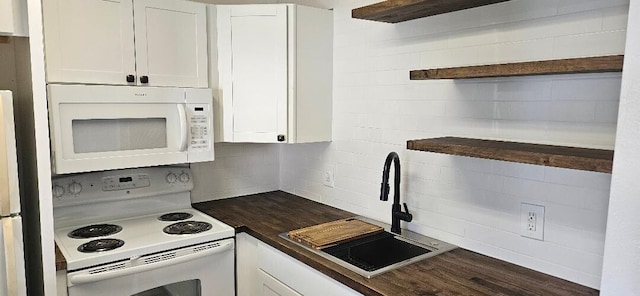 kitchen featuring sink, white cabinets, white appliances, and wood counters