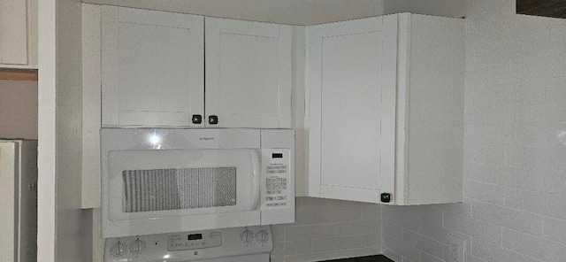 room details featuring washer / clothes dryer and white cabinets