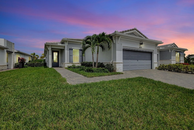 view of front facade with a yard and a garage