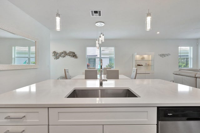 kitchen with dishwasher, white cabinets, and hanging light fixtures