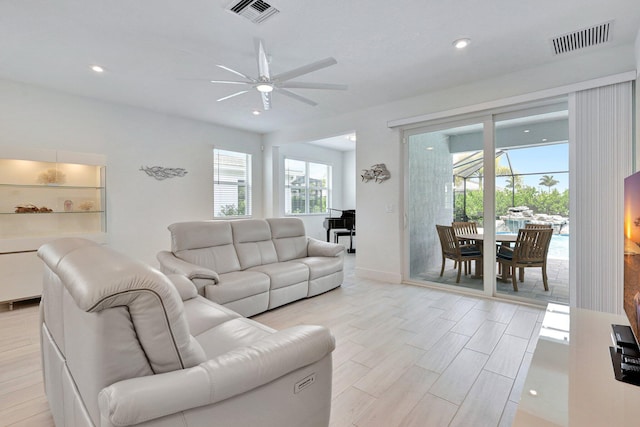 living room with light hardwood / wood-style floors and ceiling fan